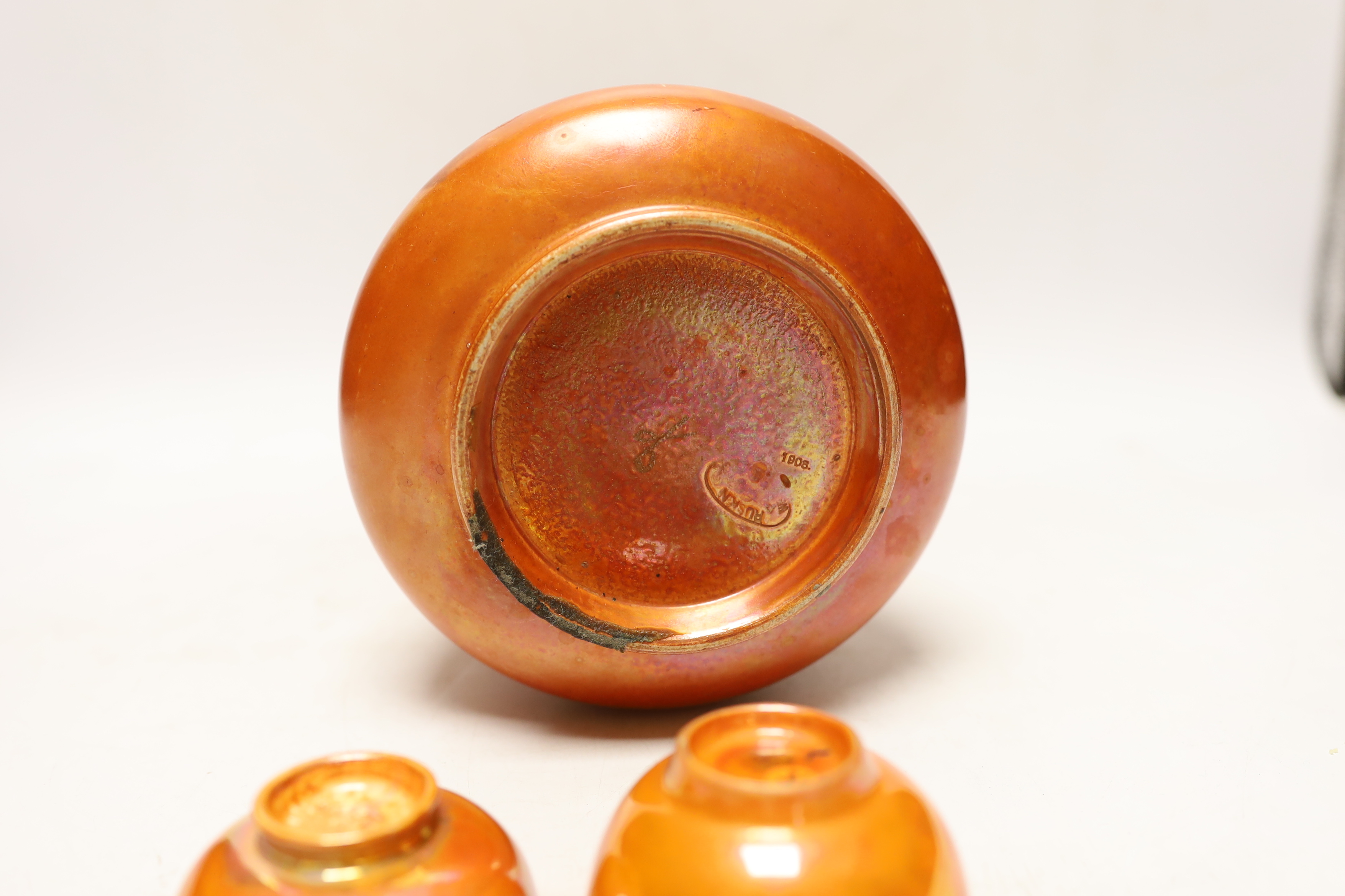 A Ruskin orange glazed vase (a.f) and three similar small bowls by Ruskin and Doulton, vase 23.5cm